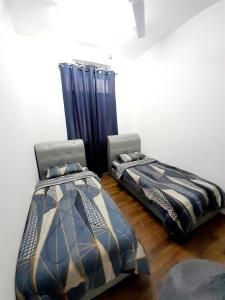 two beds sitting next to each other in a room at CASARIA HOMESTAY PD 3Bedrooms Bungalow House in Port Dickson