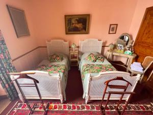 2 camas en una habitación con sillas y espejo en Quimper Centre, en Quimper