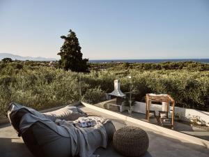 a couch on a patio with the ocean in the background at Kapodistria Luxury Villas - 3-Bedroom Villas with Private Pool, by ZanteWize in Planos