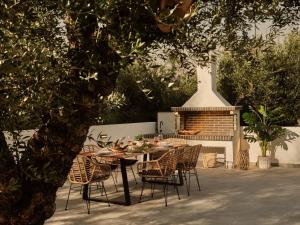 a table and chairs with a table and a fireplace at Kapodistria Luxury Villas - 3-Bedroom Villas with Private Pool, by ZanteWize in Planos