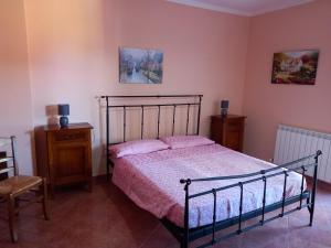 ein Schlafzimmer mit einem Bett mit rosa Kissen darauf in der Unterkunft La casa delle fate in Giave