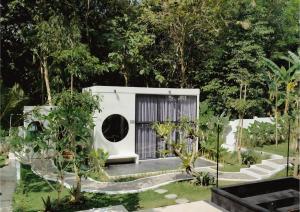 a house in a garden with trees in the background at The Volter Yogyakarta in Ngingas