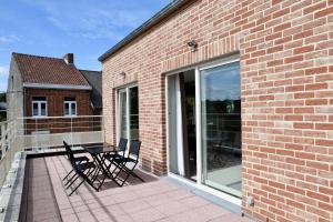 a patio with two chairs and a table on a balcony at Becosy Loft en duplex avec terrasse et 3 chambres in Mons