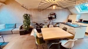 Beloeil的住宿－BeCosy Triplex chic et moderne style Loft，厨房以及带木桌和椅子的客厅。