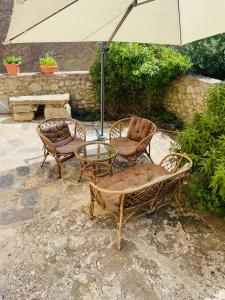 2 Stühle und ein Tisch mit Sonnenschirm in der Unterkunft San Nicolò Holiday Home in Montalbano Elicona