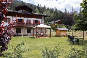 uma casa com uma mesa e cadeiras num quintal em Le Rêve em Courmayeur