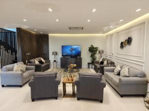 sala de estar con sofás y TV de pantalla plana. en Al Qand Chalet For Families Only, en Bahía de la Media Luna