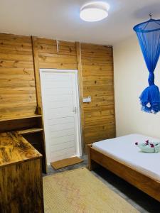a bedroom with a bed and a door with a blue curtain at Jambiani Backpackers Hostel in Jambiani
