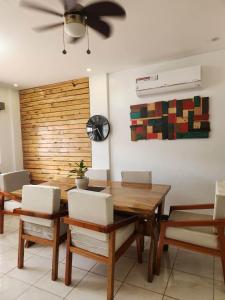 a dining room with a wooden table and a ceiling fan at Marinduque Bed and Breakfast in Maniwaya