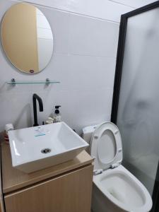 La salle de bains est pourvue d'un lavabo, de toilettes et d'un miroir. dans l'établissement Marinduque Bed and Breakfast, à Maniwaya