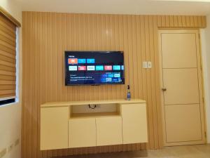 un salon avec une télévision fixée au mur dans l'établissement Marinduque Bed and Breakfast, à Maniwaya