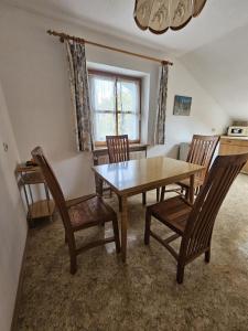 a dining room with a wooden table and chairs at Ferienwohnung Oblfing in Schöllnach