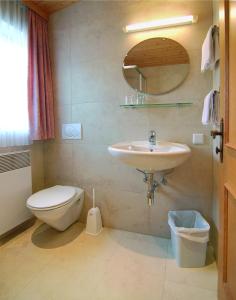 a bathroom with a sink and a toilet and a mirror at Gasthof Bad Sonnenberg in Nüziders