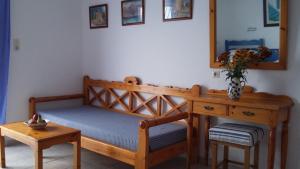 a bedroom with a bed and a table and a mirror at Kavos Bay Apartments Elounda in Elounda