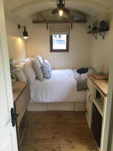 um quarto com uma cama num pequeno quarto em Shepherd's Hut. Shower & WC. Deck. Amazing view em Longhope