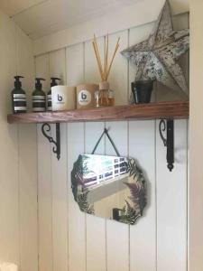 a shelf with a mirror and a star on a wall at Shepherd's Hut. Shower & WC. Deck. Amazing view in Longhope