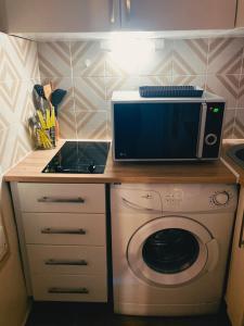 a kitchen with a microwave and a washing machine at STUDIO GARE MONTPARNASSE in Paris