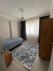 a bedroom with a bed and a door and a rug at DALAMAN 2+1 GENİŞ KİRALIK DAİRE in Dalaman