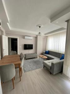 ein Wohnzimmer mit einem Sofa und einem Tisch in der Unterkunft DALAMAN 2+1 GENİŞ KİRALIK DAİRE in Dalaman