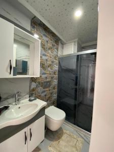 a bathroom with a toilet and a shower and a sink at DALAMAN 2+1 GENİŞ KİRALIK DAİRE in Dalaman