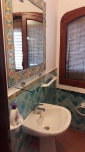 La salle de bains est pourvue d'un lavabo blanc et d'un miroir. dans l'établissement Venere Holidays, à Altavilla Milicia
