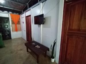 a room with a table and a tv on a wall at Jardines de Luz María in Rio Celeste