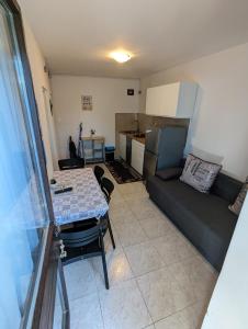 een keuken en een woonkamer met een tafel en een bank bij ground floor apartment 50m from beach in Srima