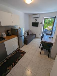 een keuken en een woonkamer met een tafel en een bank bij ground floor apartment 50m from beach in Srima