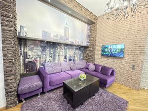 Sahil Lux في باكو: غرفة معيشة مع أريكة أرجوانية وتلفزيون