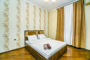 a bedroom with a bed with two shoes on it at Apartment Lux in Baku