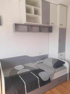 Cama en habitación con armarios blancos en CENTAR, en Kumanovo