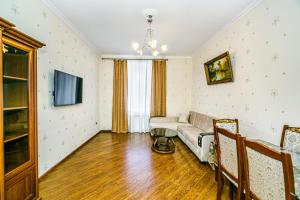 een woonkamer met een bank en een tv bij Apartment Lux in Baku