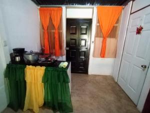 a room with a table with colorful curtains and a door at Jardines de Luz María in Rio Celeste