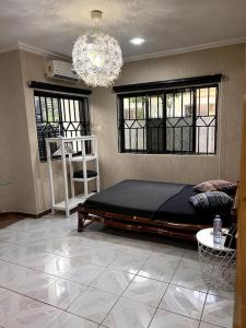 um quarto com uma cama grande e um lustre em Relaxinhaatso - 4 Bedroom luxury house with pool em Haatso