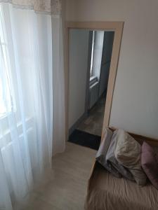 um quarto com uma cama com um espelho e uma janela em Appartement résidence Sarciron em Le Mont-Dore