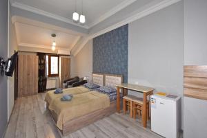 a bedroom with a bed and a table and a desk at Komitas Residence in Yerevan