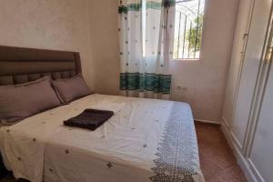 un letto con una coperta in una camera da letto di Airport apartment a Marrakech