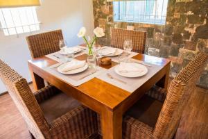 a wooden table with chairs and plates and flowers on it at Island Villa in Grand Gaube