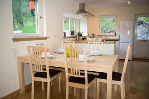 uma cozinha e sala de jantar com uma mesa de madeira e cadeiras em Lochleven Seafood Cottage em Onich