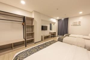 pokój hotelowy z 2 łóżkami i telewizorem w obiekcie Hotel One w Cebu
