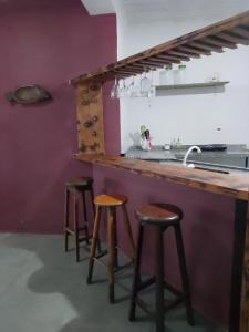 a kitchen with a counter with stools and a sink at Loft Térreo no Centro in Búzios