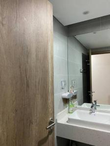 La salle de bains est pourvue d'un lavabo et d'un miroir. dans l'établissement 2PN sân vườn Solforest, Ecopark, à HÆ°ng YÃªn