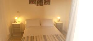 a bedroom with a bed with two lamps on two tables at Chez Rime Superbe appartement 80 m avec piscine. in Mohammedia