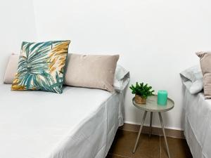 a bed with a pillow and a table with a plant at Casa Almanzora, apartamento de 1 dormitorio, wifi, parking gratuito in Zurgena