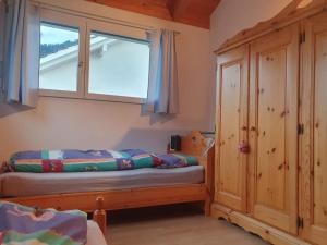 a bedroom with a bed and a window at Casa Nadja, nähe Skigebiet Flims-Lax in Ems