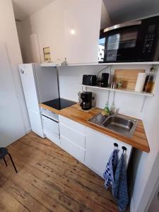 a small kitchen with a sink and a microwave at Charmant duplex gare St jean in Bordeaux