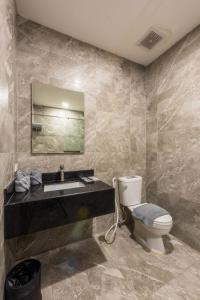 W łazience znajduje się umywalka, toaleta i lustro. w obiekcie Hotel One w Cebu