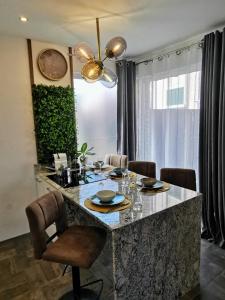 une cuisine avec une table, des chaises et une horloge dans l'établissement Apartment Beachfeeling, à Srima