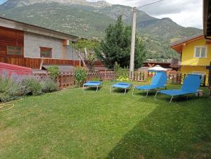 une cour avec des chaises et une table ainsi qu'une maison dans l'établissement Casa vacanze Gianluca, à Aoste