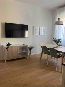 een woonkamer met een eettafel en een televisie bij Pelusia apartment in Modena